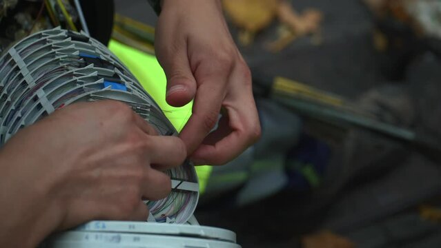 hands working on fiber optics cables