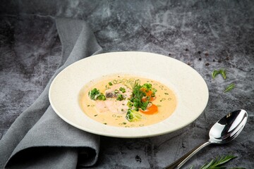 Scandinavian fish soup with herbs on a white plate side view