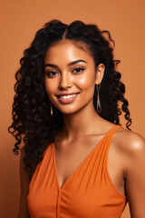 Woman with curly hair wearing orange dress and gold hoop earrings.