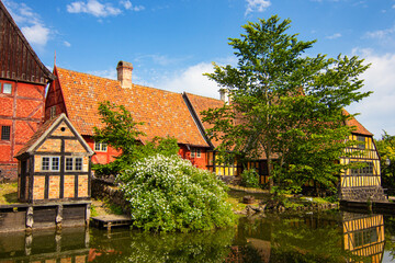 Fototapeta na wymiar Half-Timbered Traditional Danish Houses near pond at Den Gamle By (The Old Town in English), an open-air town museum located in the Aarhus, Denmark