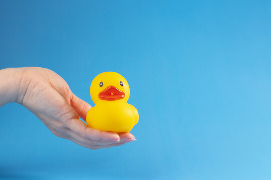 Baby's bath friend, rubber duck in hand, bath time fun, yellow ducky
