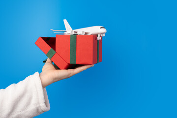 plane in present box in hand, christmas flight sale, winter travel, airplane tickets, holiday...