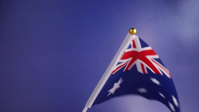Australian flag in hand on a blue background, independence national day of Australia, country freedom, patriotism