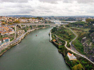 Fototapeta premium Beautiful spectacular aerial perspective of Porto City. View of River Douro and Dom Luis I Bridge. Famous travel destination in Portugal. Cloudy day.