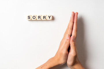 sorry hand sign and sorry word written with dice, isolated on white background