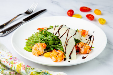shrimp with avocado slices and arugula with teriyaki sauce side view