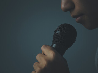 man holding a microphone Talking or announcing on a dark picture