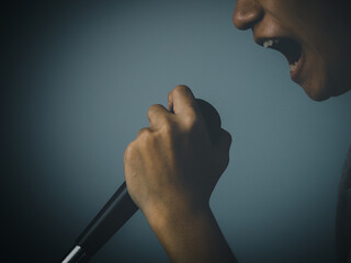 A man holding a microphone shouts or announces.