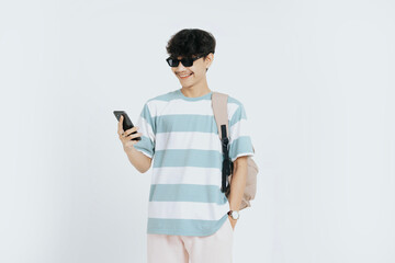 Happy asian young man student looking to smartphone with isolated white background