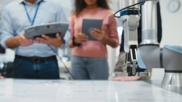 Close Up Of Group Of College Or University Engineering Students In Robotics Class With Male Teacher