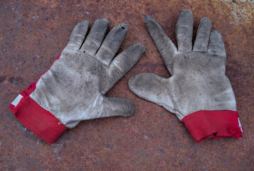 Old work gloves on rusty iron plate