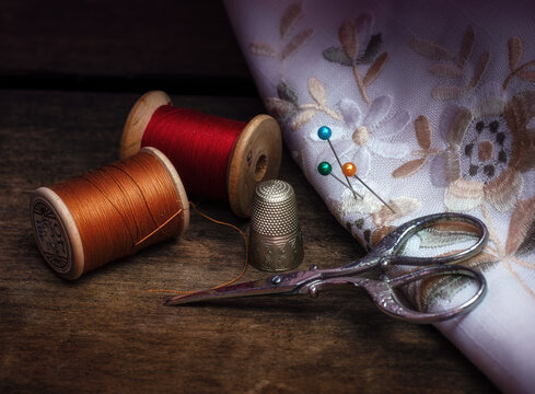 still life composition with needles, thimble, spools of thread