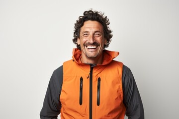 Fototapeta premium Portrait of a happy man in his 40s dressed in a water-resistant gilet against a white background. AI Generation