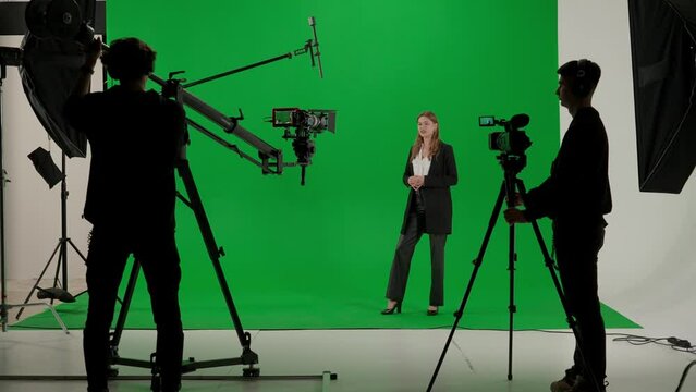 News anchor at work, woman journalist presenter telling weather news, view of a backstage studio TV news shooting, chroma key template.