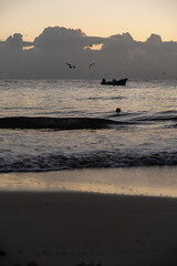 Fototapeta premium Sunset in Playa del Carmen, Mexico with clouds in the background and birds flying overhead