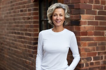 Portrait of a content woman in her 60s sporting a long-sleeved thermal undershirt against a vintage brick wall. AI Generation