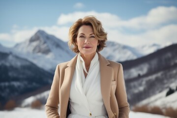 Portrait of a blissful woman in her 50s dressed in a stylish blazer against a snowy mountain range. AI Generation
