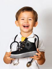 child in a doctor's uniform and a stethoscope shows a shoe, orthopedic shoes