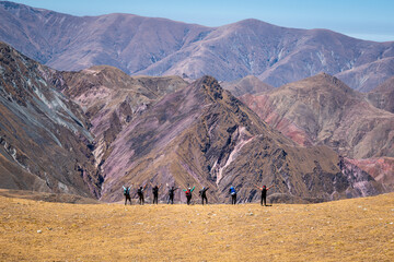 Grupo de montañistas con los brazos abiertos en la montaña