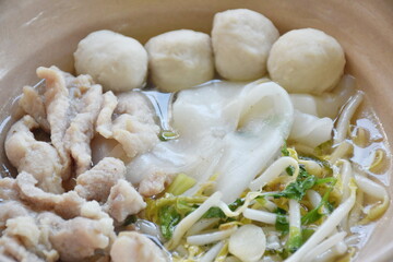 boiled white large noodles with soft slice pork and ball in clear soup on bowl