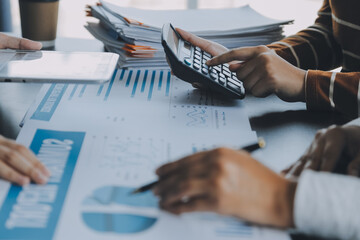 Financial analysts analyze business financial reports on a digital tablet planning investment project during a discussion at a meeting of corporate showing the results of their successful teamwork. - obrazy, fototapety, plakaty