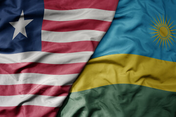 big waving national colorful flag of rwanda and national flag of liberia .