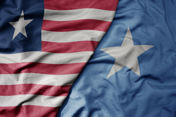 Obraz premium big waving national colorful flag of somalia and national flag of liberia .