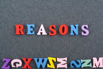 REASONSword on black board background composed from colorful abc alphabet block wooden letters, copy space for ad text. Learning english concept.