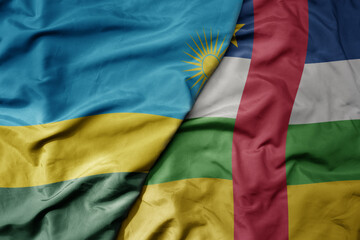 big waving national colorful flag of central african republic and national flag of rwanda .