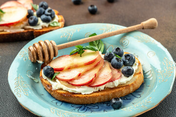 Summer Bruschetta With cream cheese, honey, peaches and blueberries, Food recipe background. Close up