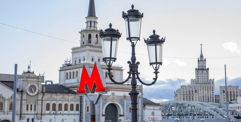Moscow metro sign and Stalinist architecture on background. Selective focus on metro sign.