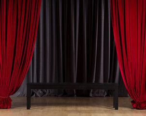 Old wooden black sofa on the show stage. Table on empty stage with red curtains