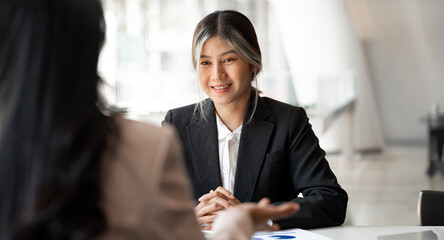 Bashful woman taking interview sitting at office