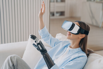 Smiling woman with bionic arm explores virtual reality, merging cutting-edge tech with human...