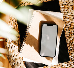 Blank path screen mobile phone with mockup on various notepads in sunlight with shadows