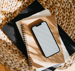 Blank path screen mobile phone with mockup on various notepads in sunlight with shadows