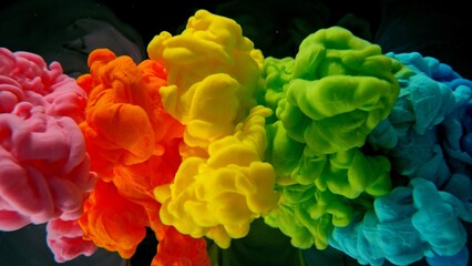 Obraz premium Colourful Rainbow Paint Drops Mixing in Water.