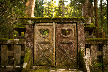 Tor auf japanischem Friedhof mit Herzen am Tag im Wald