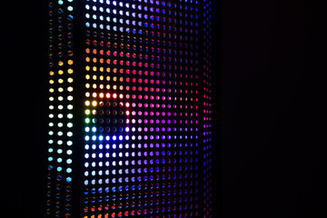 Closeup of computer case cooling fan with RGB lighting in the dark.