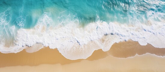 Top down aerial view of turquoise color sea water and golden beach