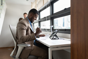 Happy African businessman working with tablet computer at office	