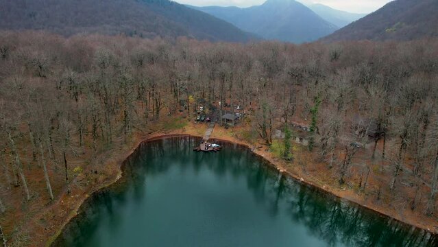 Aerial view of Montenegro Biograd Lake autumn colors and defoliated trees wooden pier and clouds with boats
