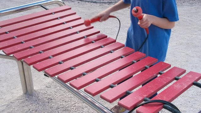 Relax on xylophone in park. A view of child make music on street xylophone in children park.