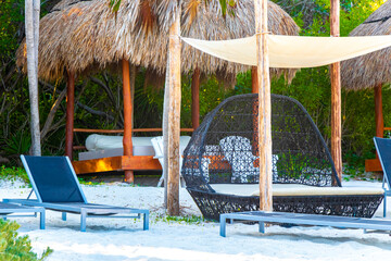Palapa thatched roofs palms parasols sun loungers beach resort Mexico.