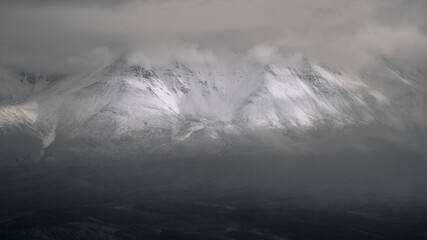 Black and white image of snow-capped mountains.