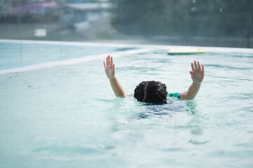 Asian child kid baby girl drowning in swimming pool. The dangerous activity water activity in the...