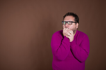 Funny fat man posing in studio on brown background. Different emotions.