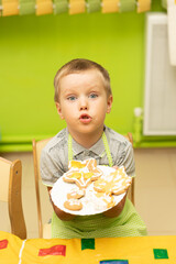 A boy at a master class prepares and paints New Year's gingerbread