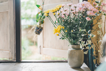Summer wildflower bouquet in a vase resting on a wooden window sill. Summer cottage with a still...