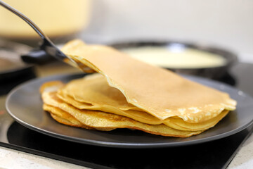 Making bliny at home. Closeup of traditional tasty thin pancakes.
